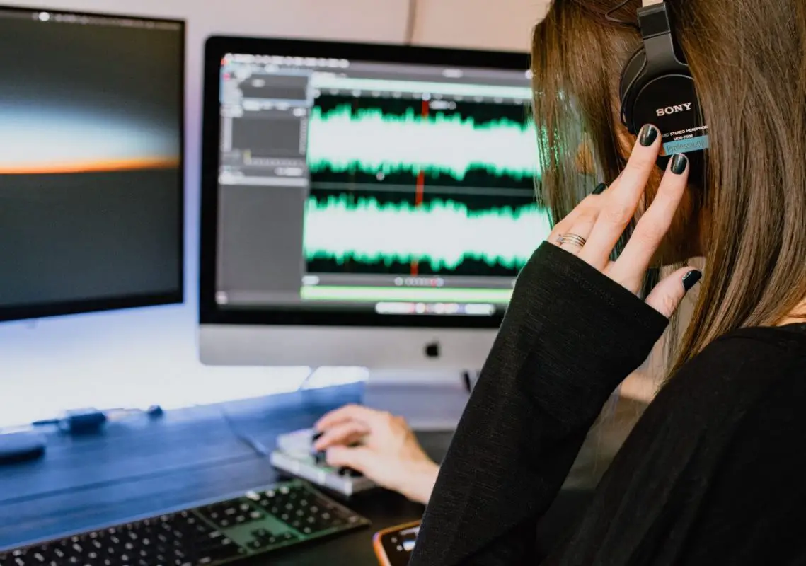 Image of a girl with a headphone in front of a monitor. Source: kelly sikkema, unsplash