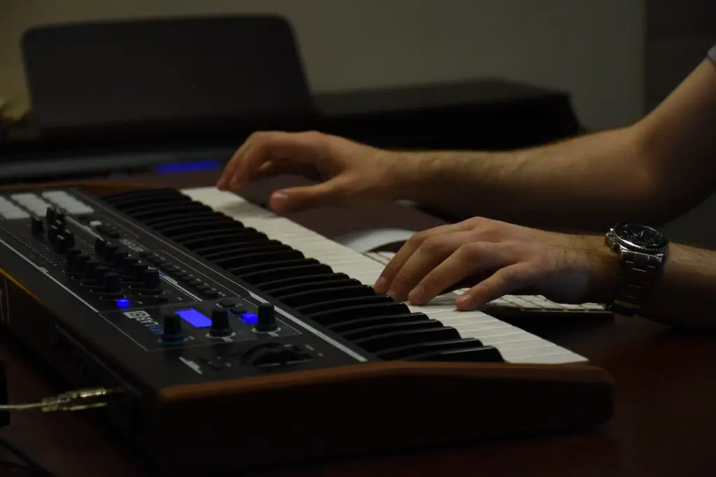 Image of a midi controller being played by someone. Source: amin asbaghipour, pexels