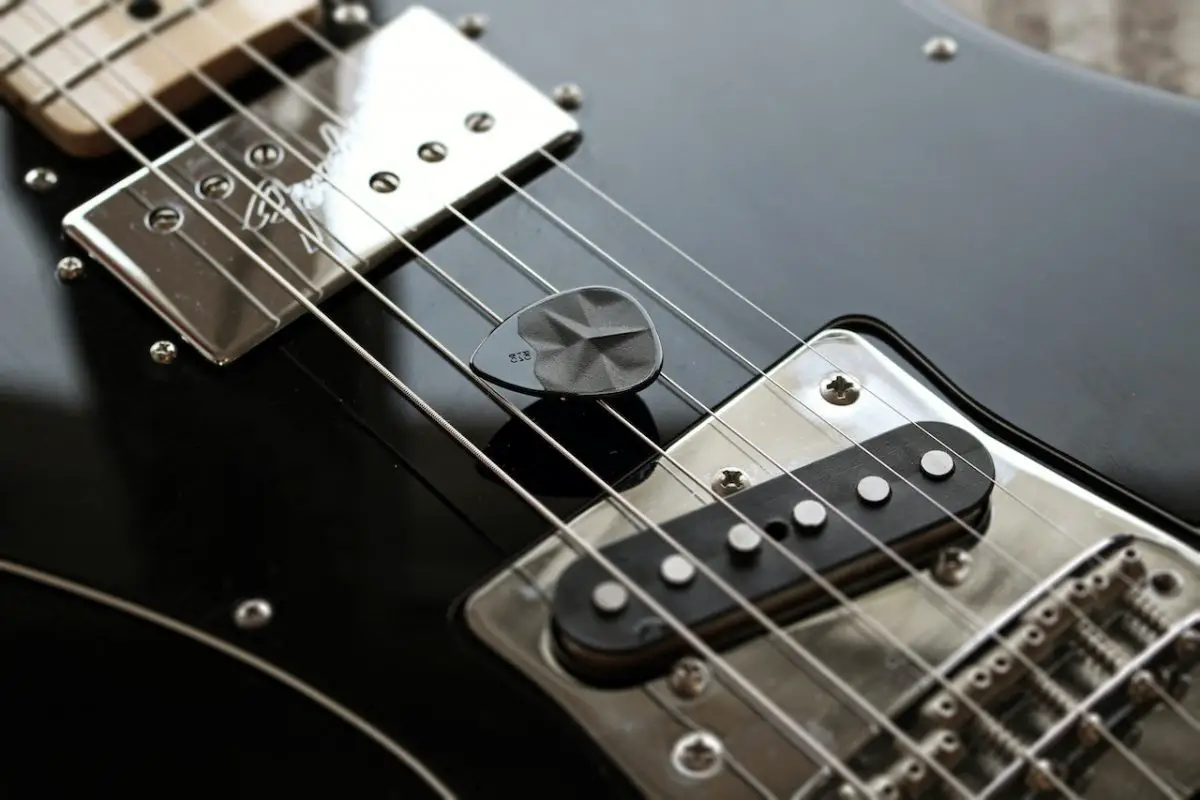 Image of a black electric guitar with an angled guitar pickup. Source: rombo, pexels