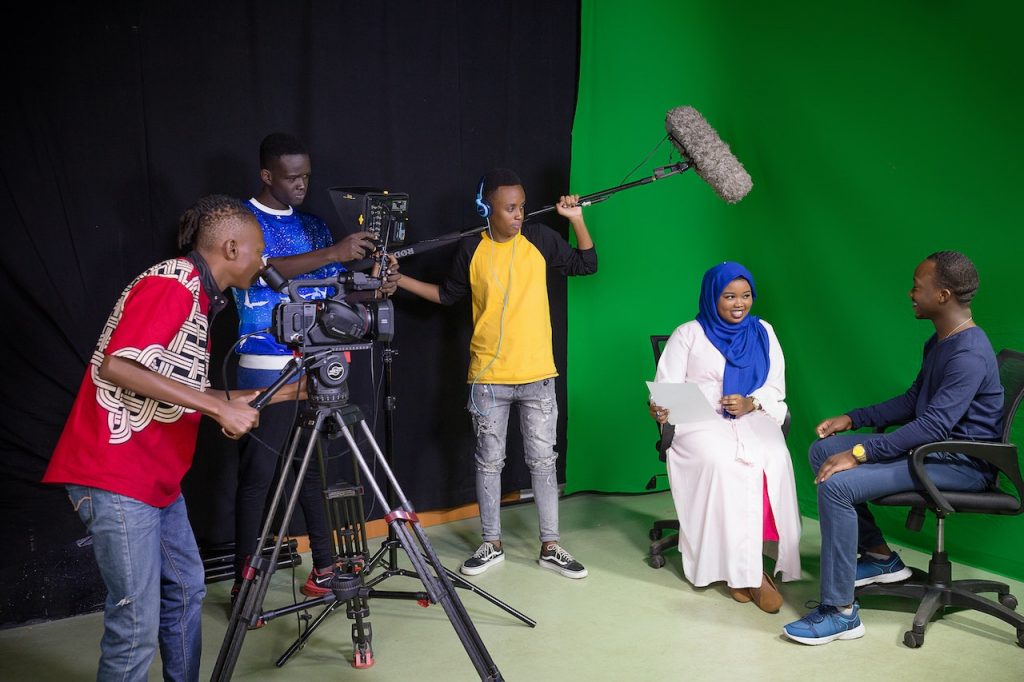 Image of a group of people using a camera and a boom microphone. Source: antony trivet, pexels