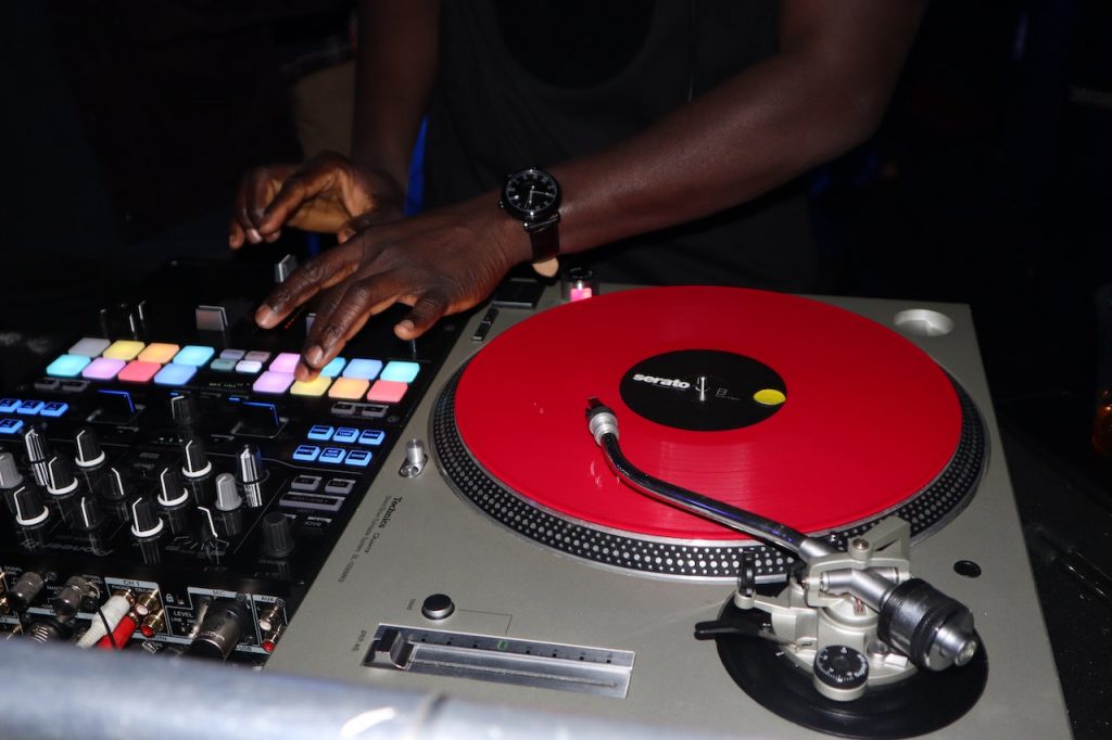 Image of a midi controllers with a red vynil beside it. Source: yaw afari, pexels