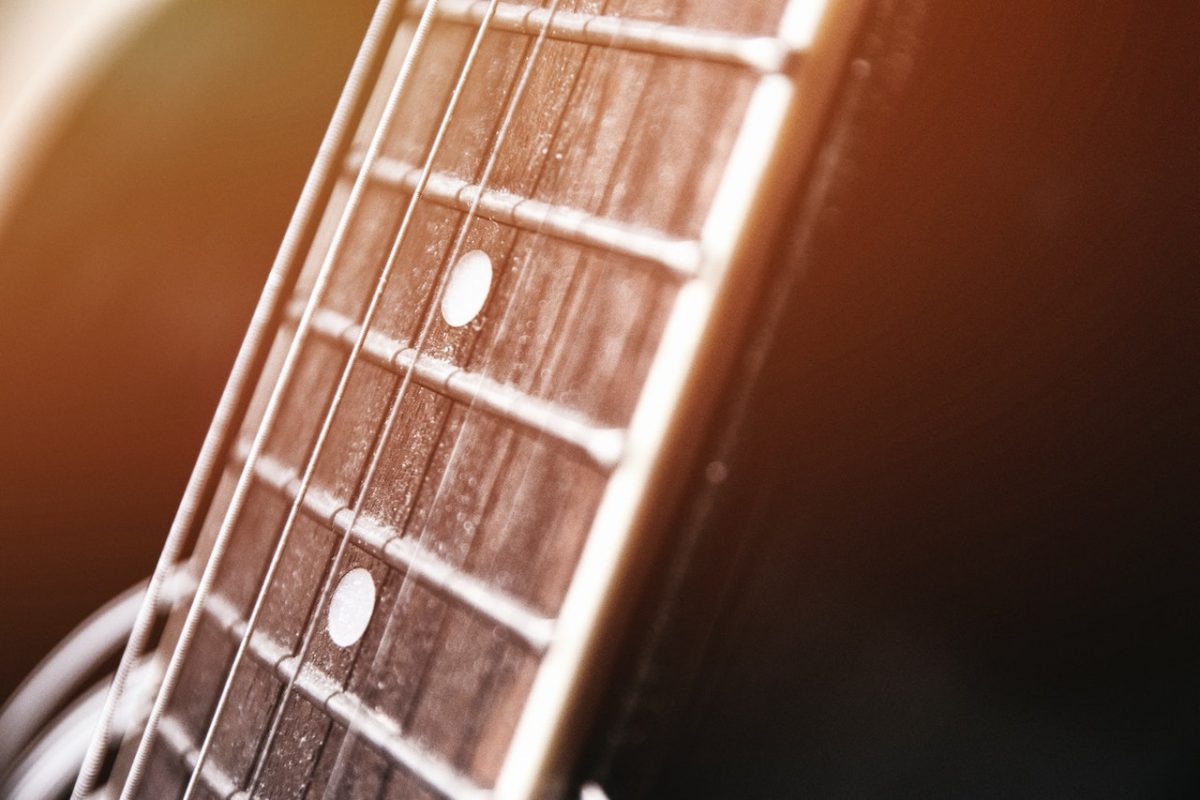 Image of guitar with complete guitars strings on it. Source: juan pablo amador, pexels