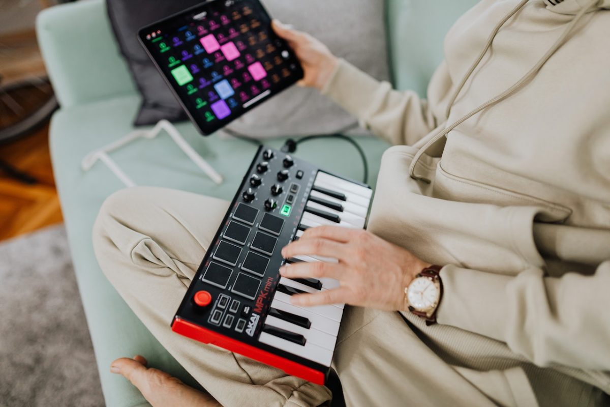 Image of someone using a portable midi controller at their home. Source: karolina grabowska, pexels