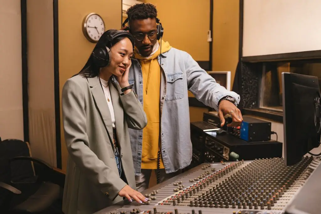 Image of a man and a woman wearing a headphones inside a recording studio. Source: antoni shkraba production, pexels