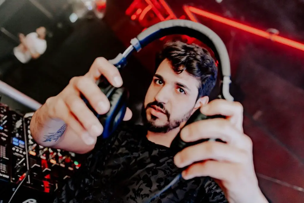 Image of a man holding a black headphones. Source: paloma clarice, pexels