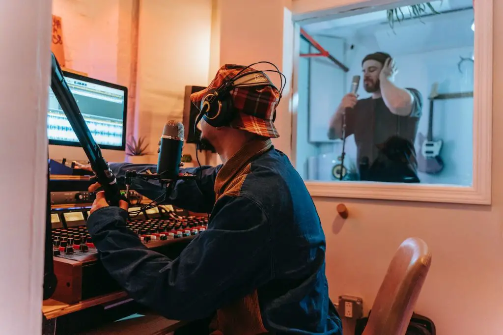 Image of a man inside a recording studio while editing audio effects. Source: anna pou, pexels