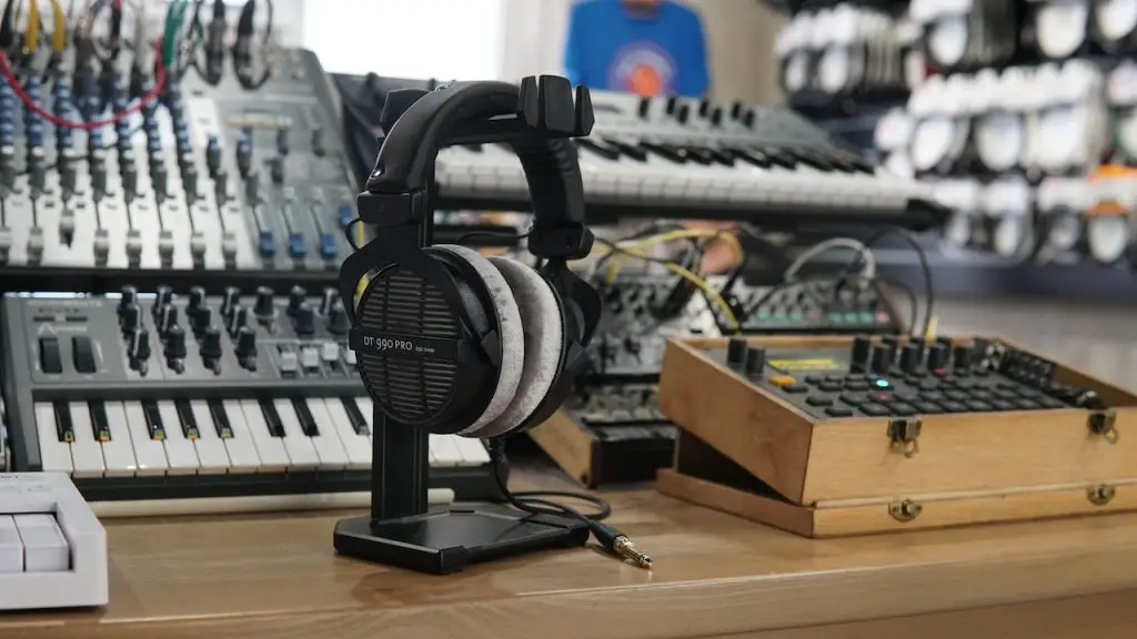 Image of a table with a black audio interface, a headphone, and other musical instruments. Source: tstudio, pexels