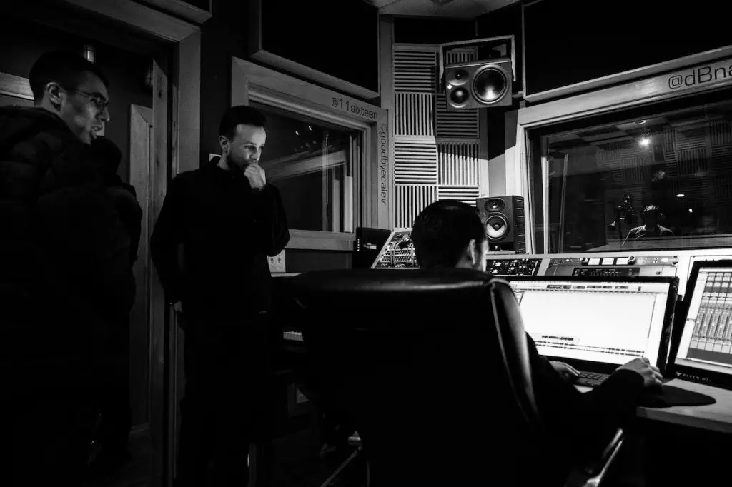 Image of men looking on a monitor inside a music studio. Source: Brett Sayles, Pexels 
