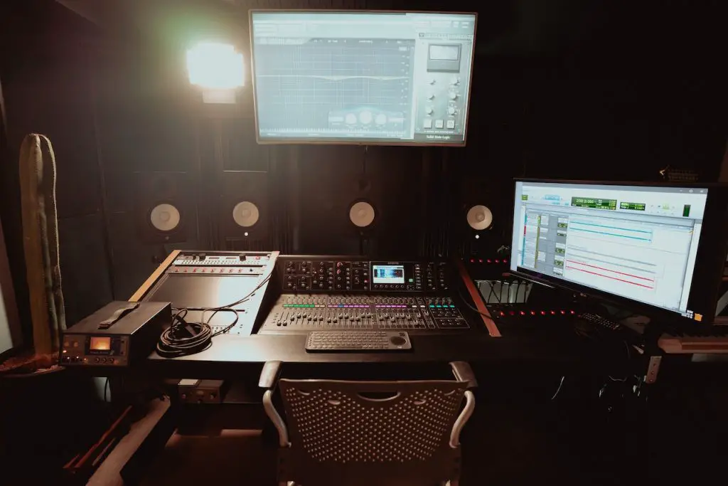Image of studio monitors with a audio mixer and lightings. Source: Los Muertos Crew, Pexels