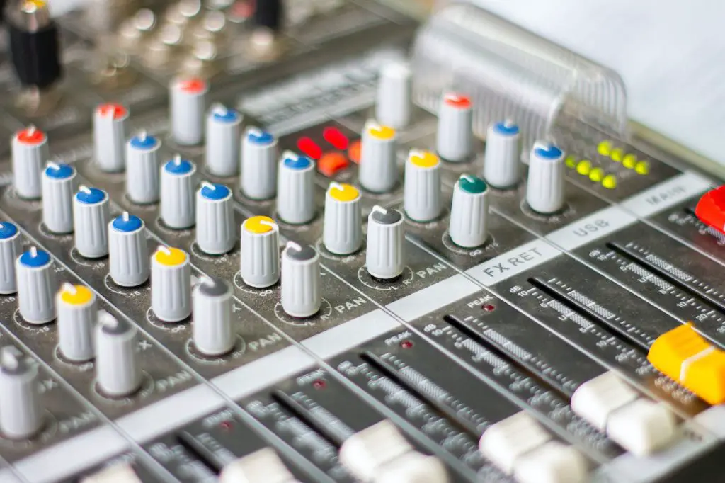 Image of an audio mixer with white, yellow, blue, and gray buttons. Source: pexels