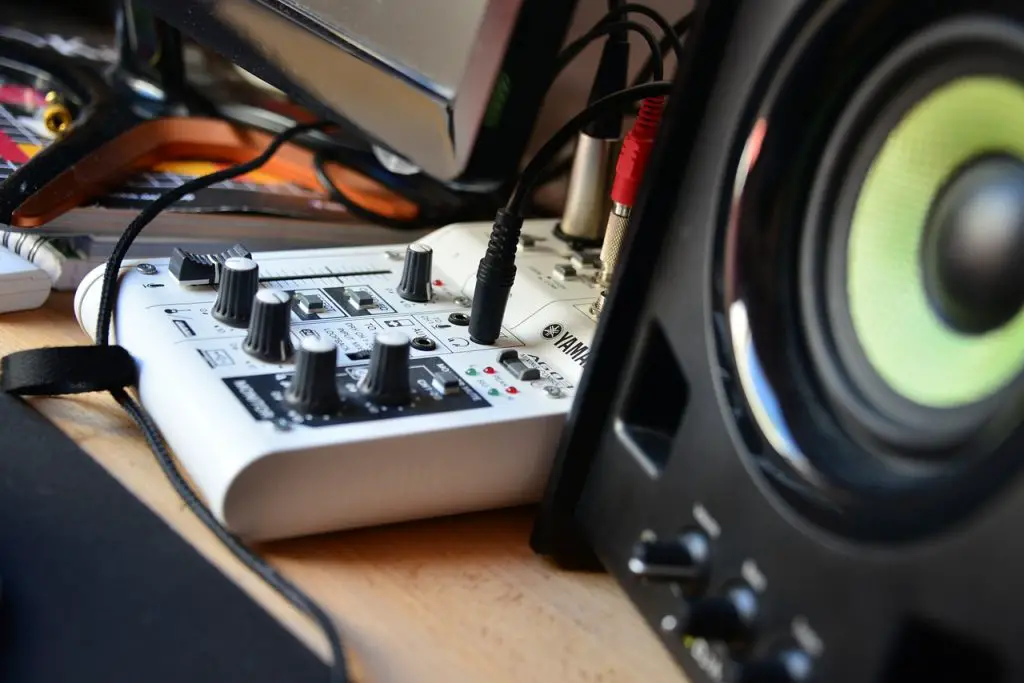 Image of a white colored audio interface connected to speakers. Source: pixabay
