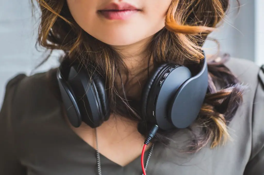 Image of a woman wearing a black wired headphones. Source: burst, pexels