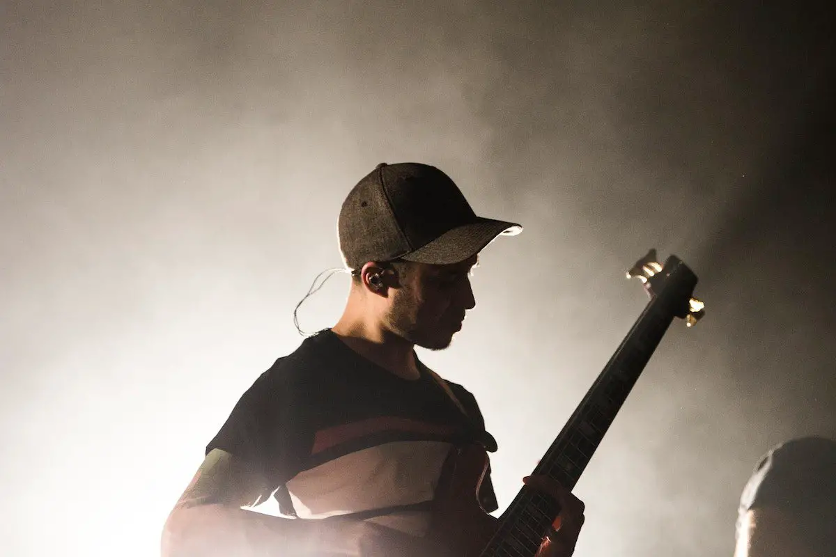 Image of a guitarist on stage with an in ear monitor source pexels