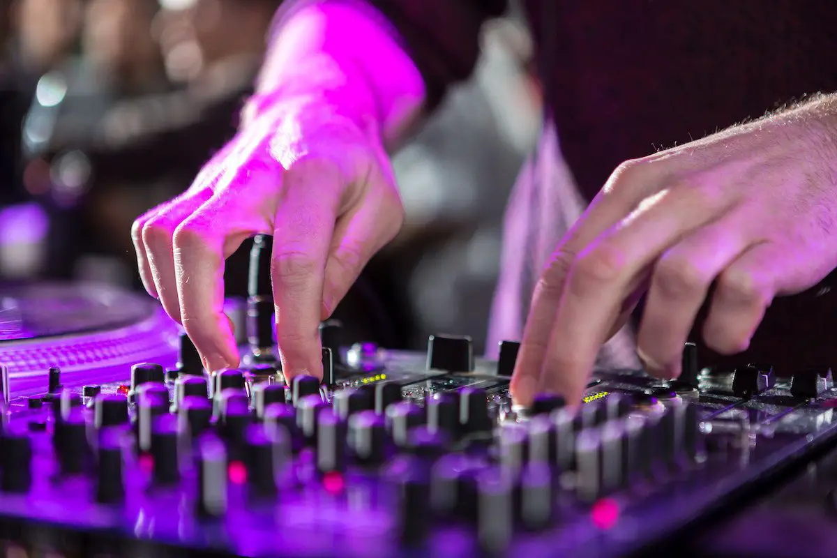Image of a man controlling an audio mixer. Source: pexels