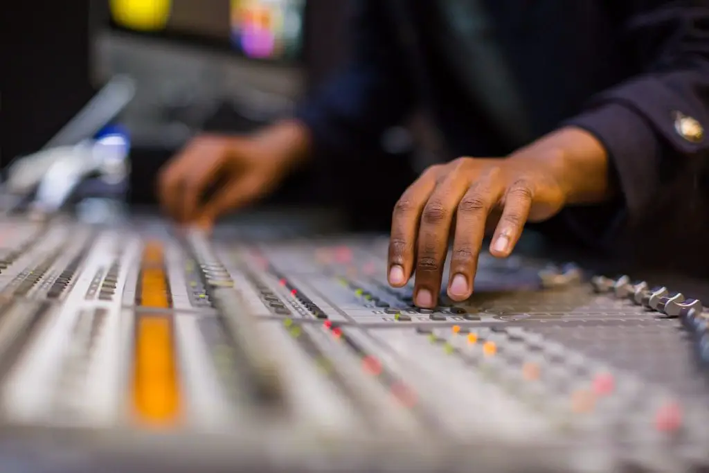 Image of a man controlling the mixing board. Source: pexels