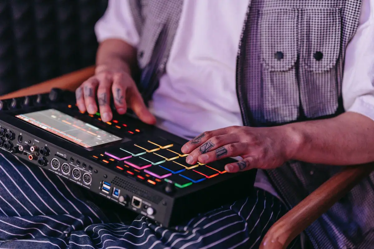 Image of a man playing a drum machine. Source: pexels
