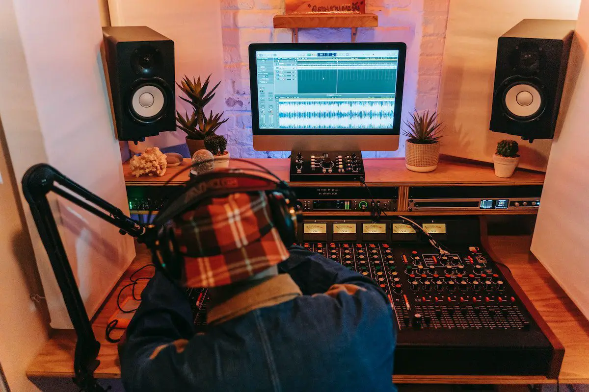 Image of a man working in a music studio. Source: pexels
