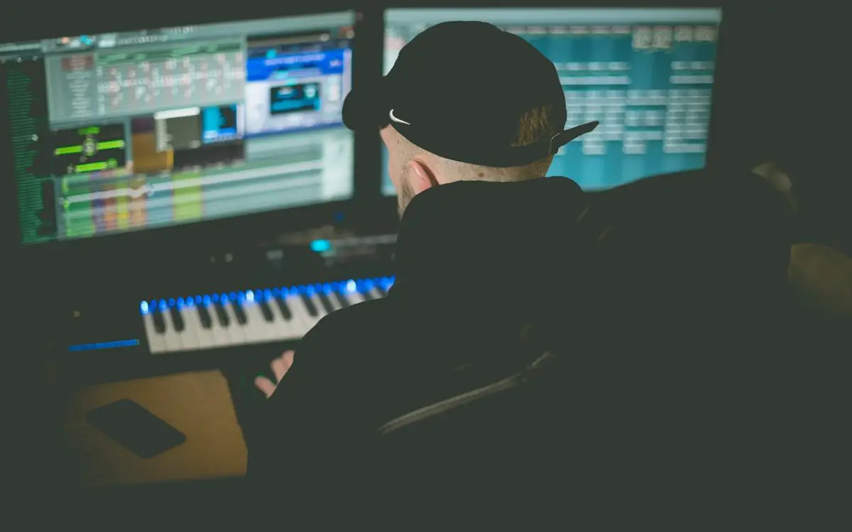 Image of an audio producer in front of two monitors. Source: pixabay