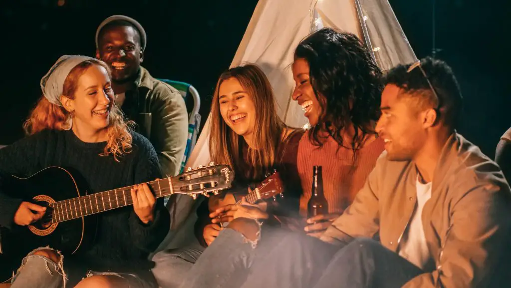 Image of five people singing and smiling together in a jam session. Source: pexels