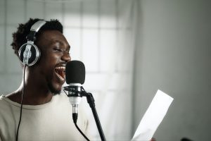 Man singing in front of a microphone. Source: Unsplash