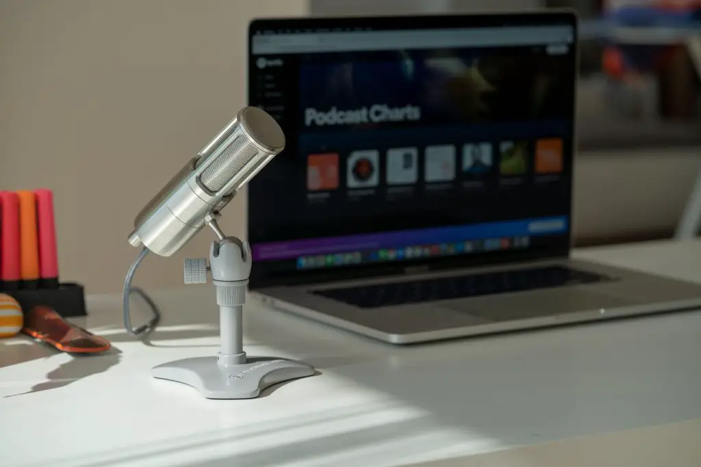 Image of a usb microphone and a laptop on a table.