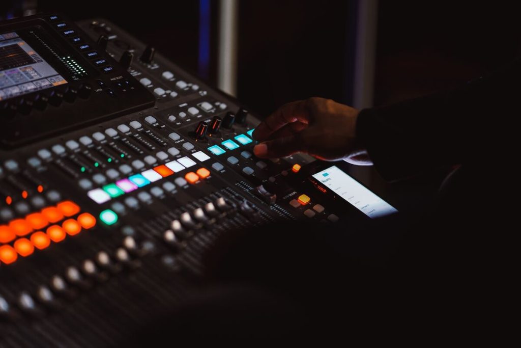 Image of a man controlling an audio mixer unsplash