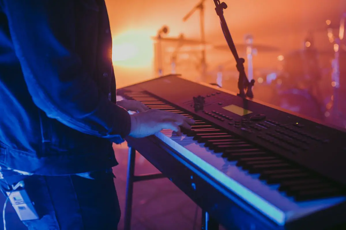 Image of a man playing his keyboard on the stage. Source: unsplash