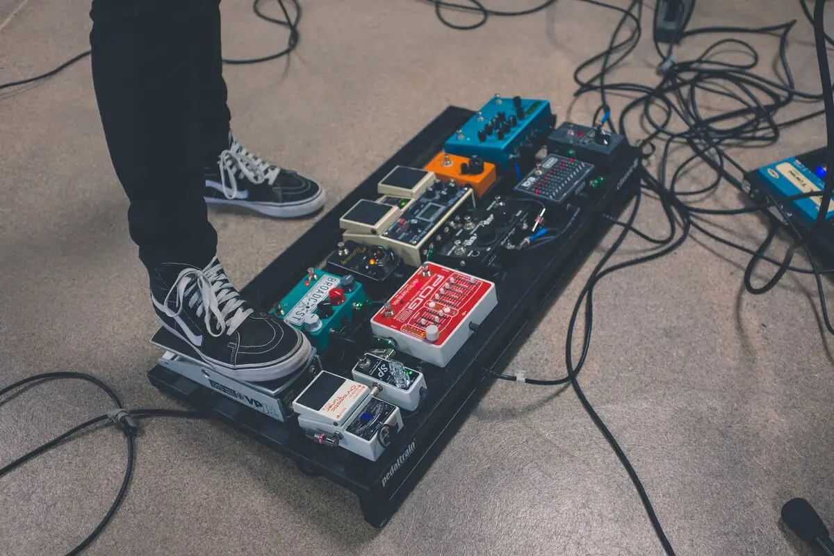 Image of a musician stepping on a loop pedal source unsplash