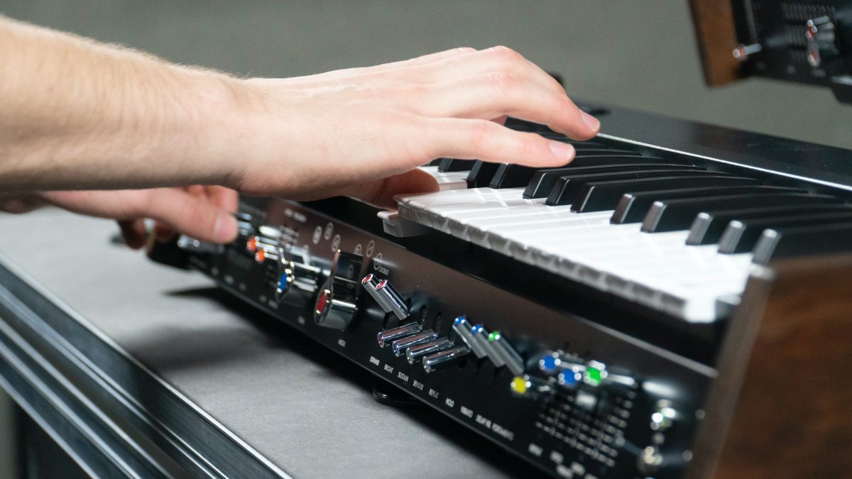 Image of a person playing a keyboard on a table. Source: unsplash