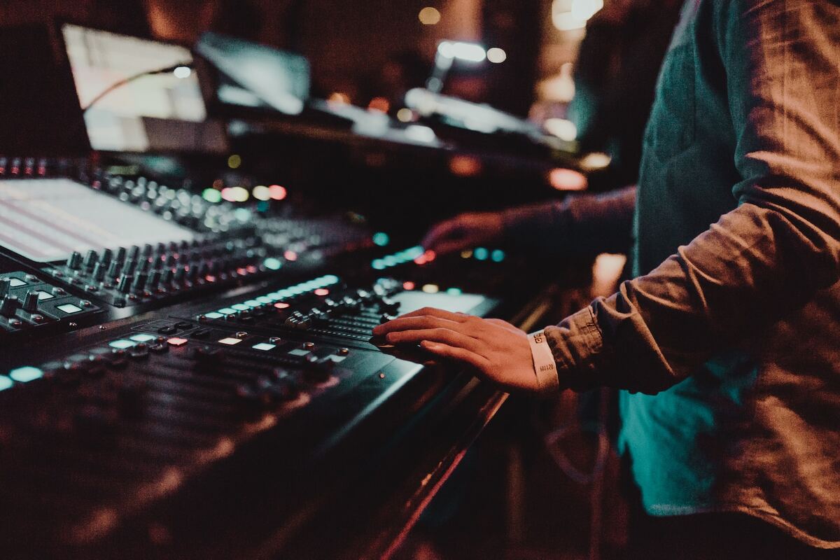 Image of an audio engineer adjusting dials. Source: unsplash