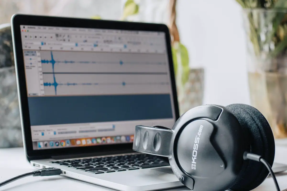 Image of headphones in front of a laptop with a sound recording. Source: Pexels