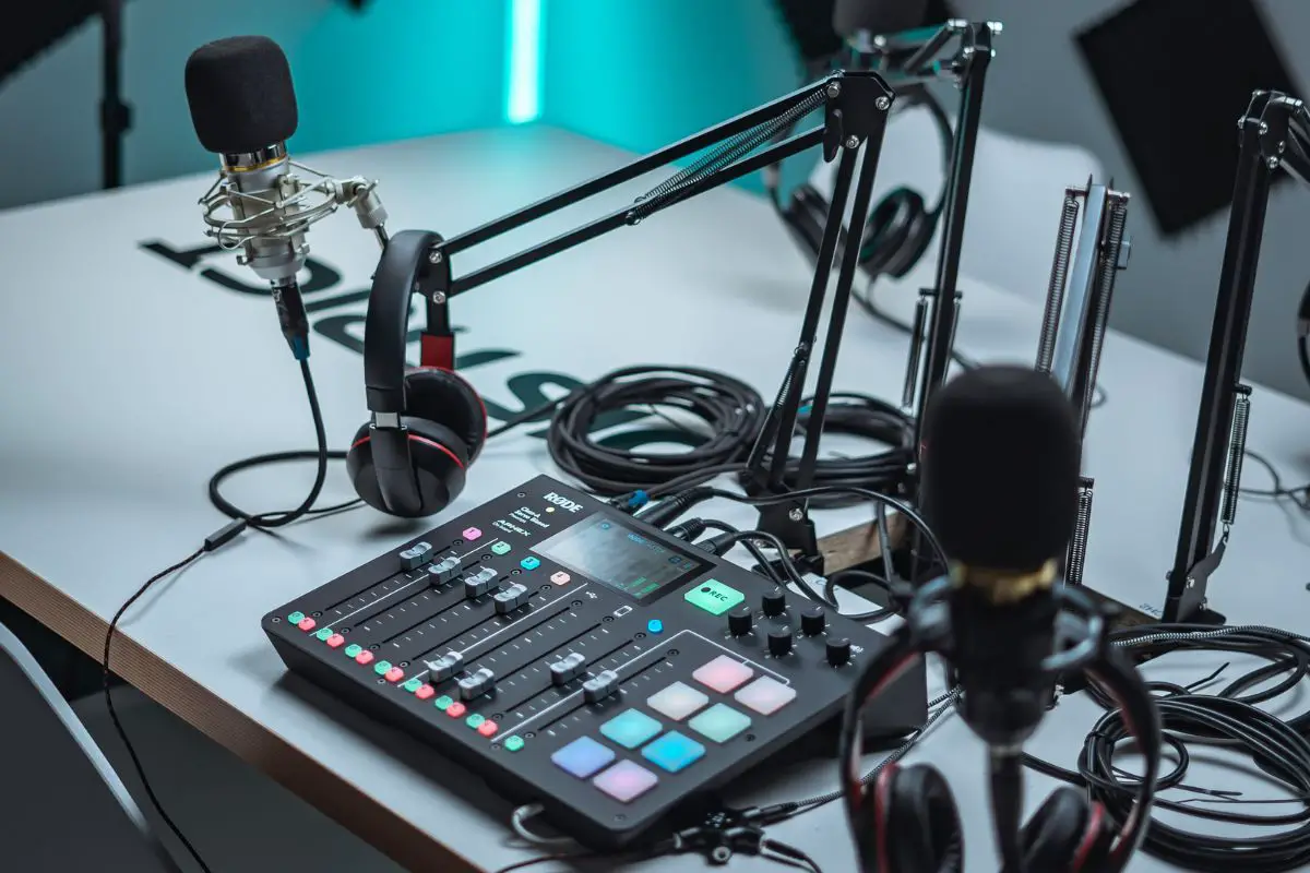 Image of microphones attached to a mike stand headphones and audio mixer. Source: unsplash