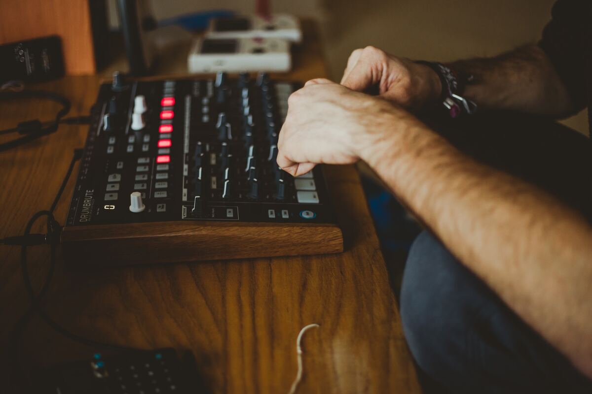 Image of a man playing with an audio interface. Source: unsplash