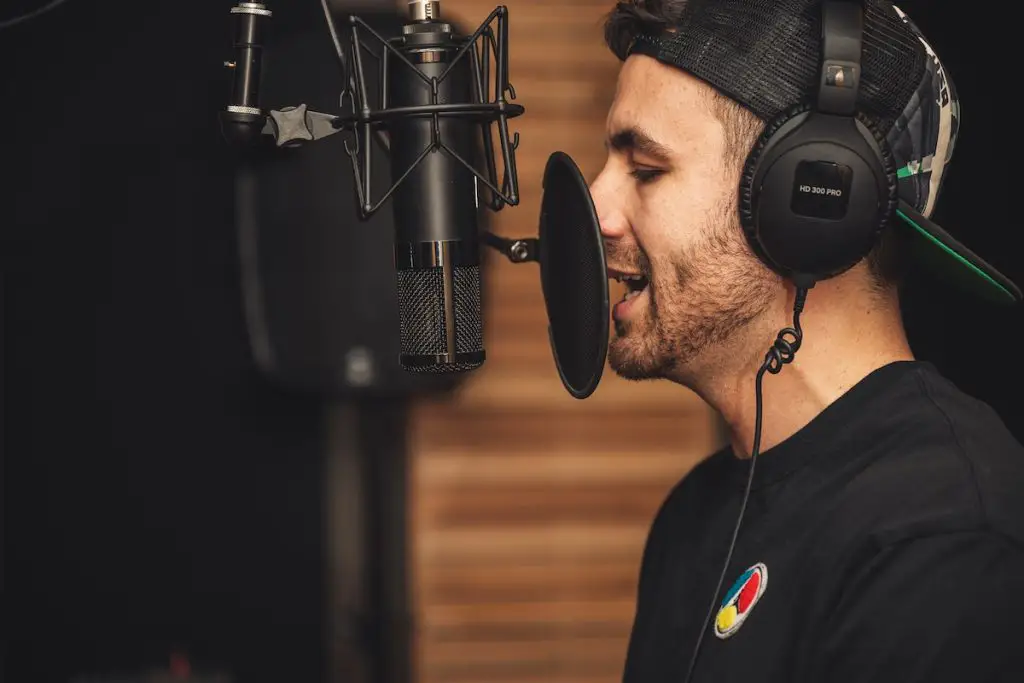 Image of a man singing in a microphone inside a recording studio pexels