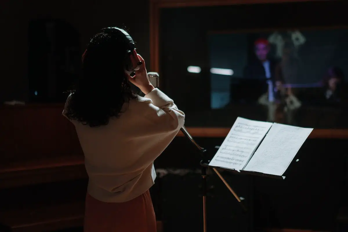Image of a singer recording music in a studio. Source: pexels