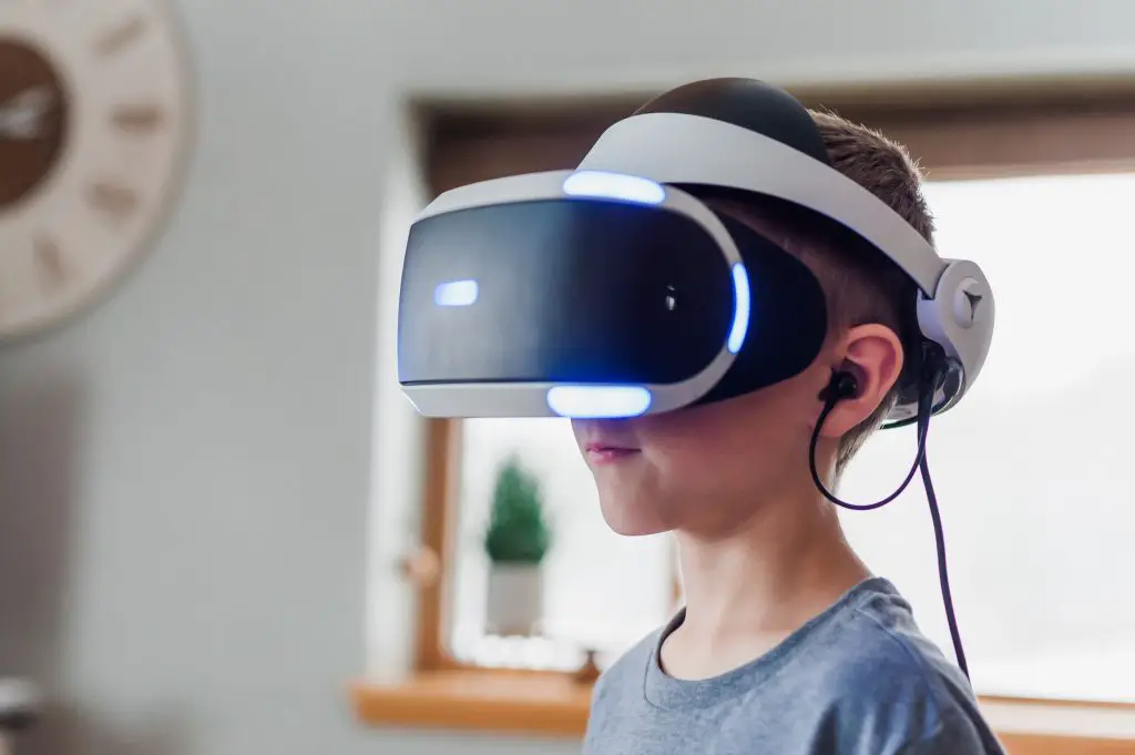 Image of child wearing a vr headset and earphones. Source: unsplash
