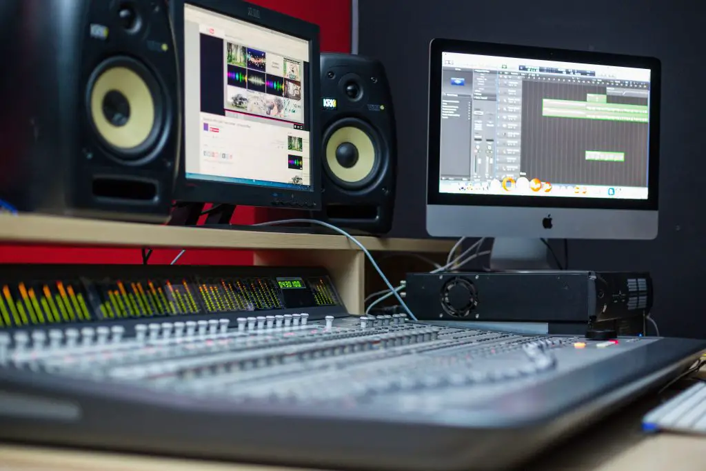 Audio recording setup with studio monitors, computer, and mixer. Source: pexels