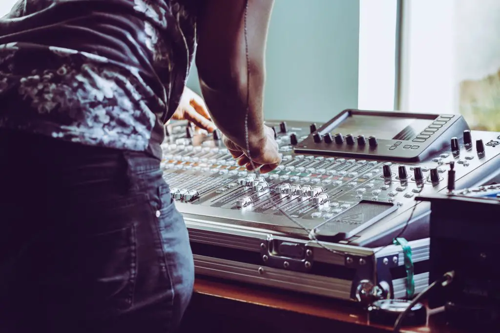 Image of a sound engineer working on a mixer. Source: unsplash