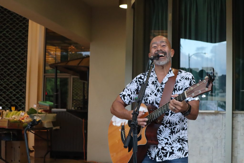 Image of a man singing and playing a guitar.