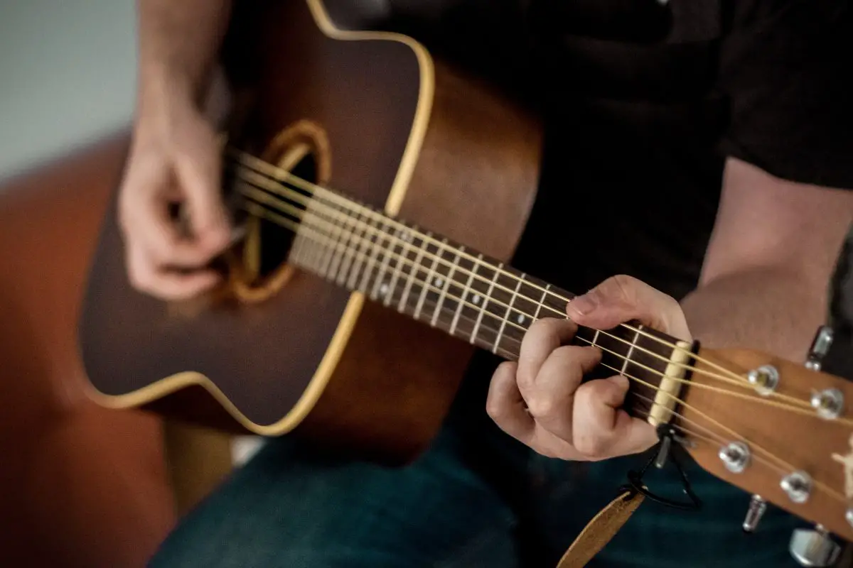 Image of a guitarist playing a guitar.