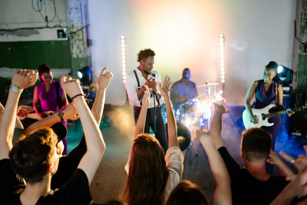 A live band performing in front of a crowd. Source: pexels