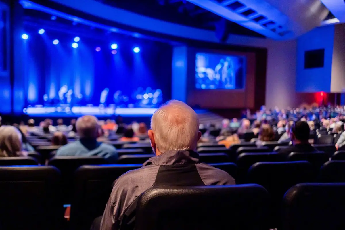 Audience in a theater looking at the stage. Source: pexels