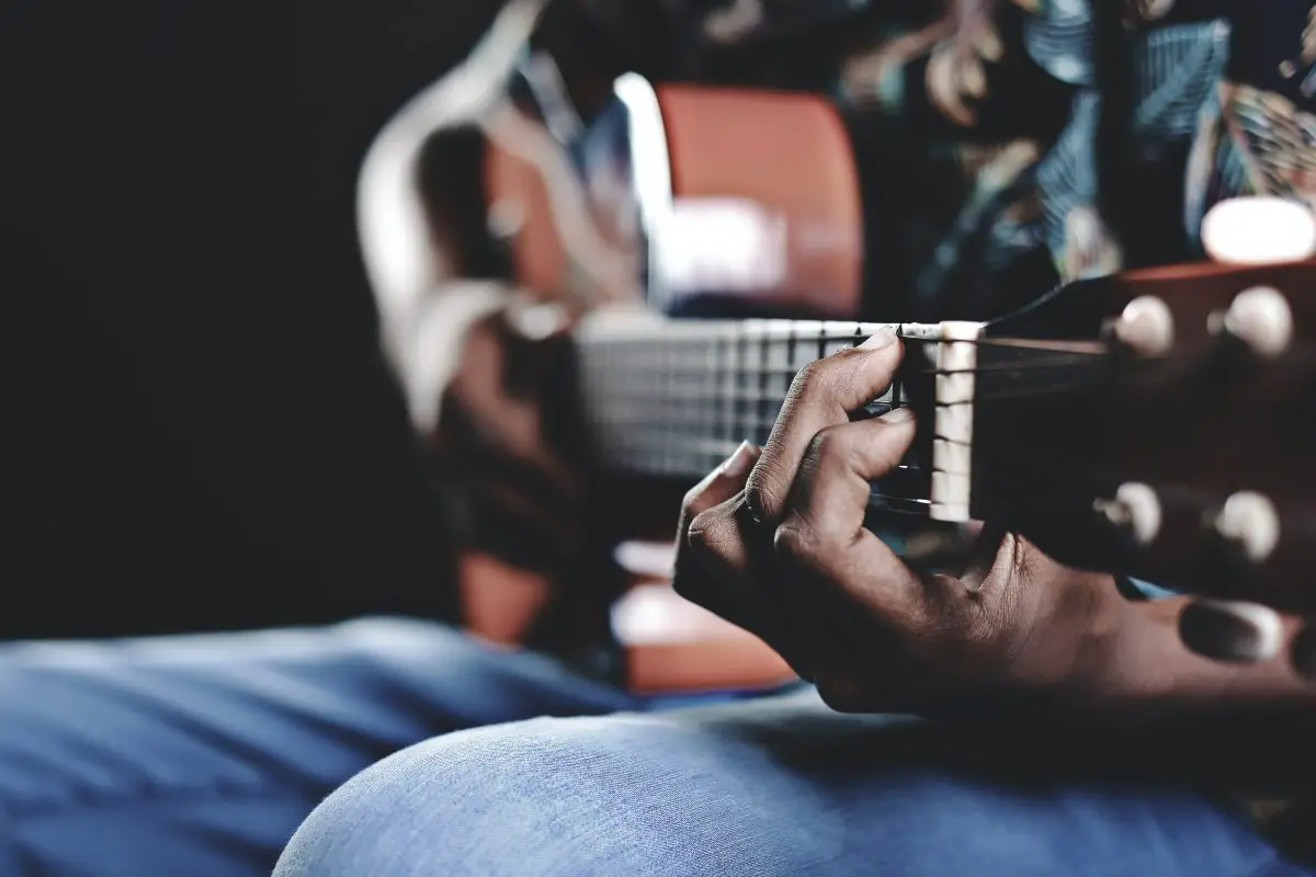 Closeup of a guitarist s hand holding a guitar. Source: unsplash