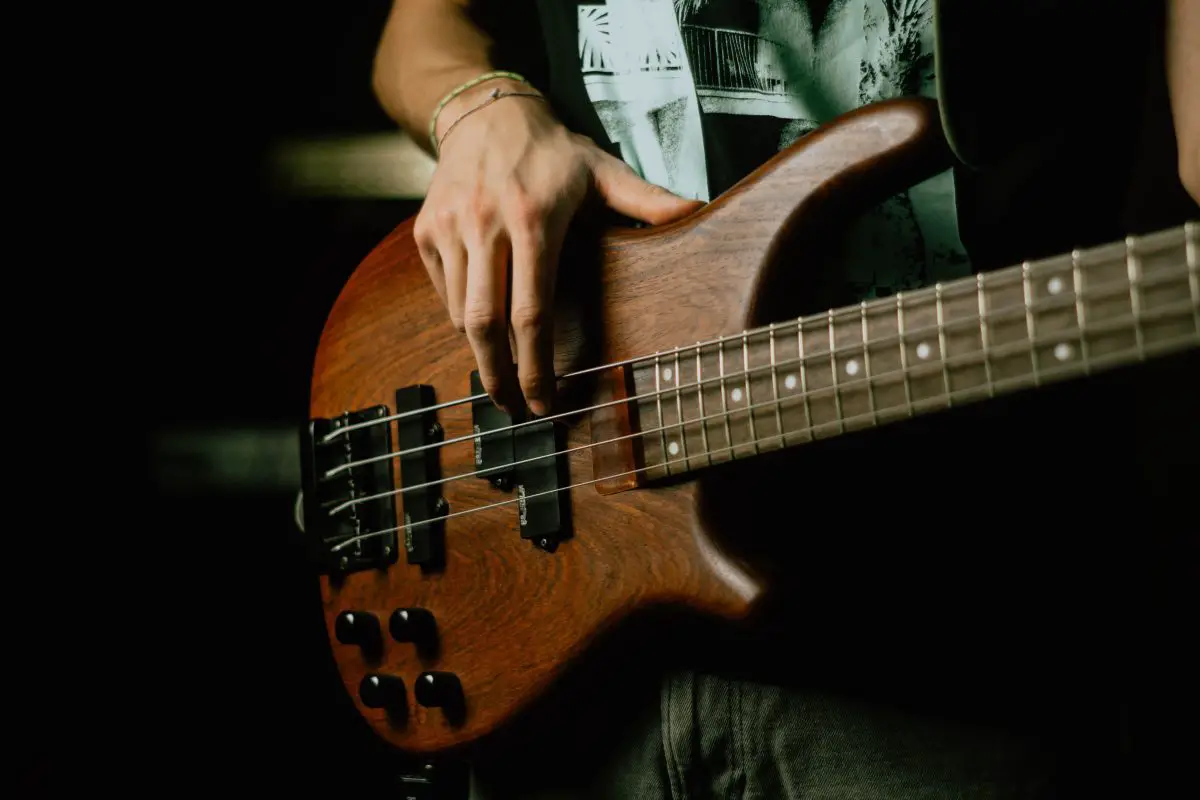 Closeup of a musician playing the bass guitar. Source: unsplash