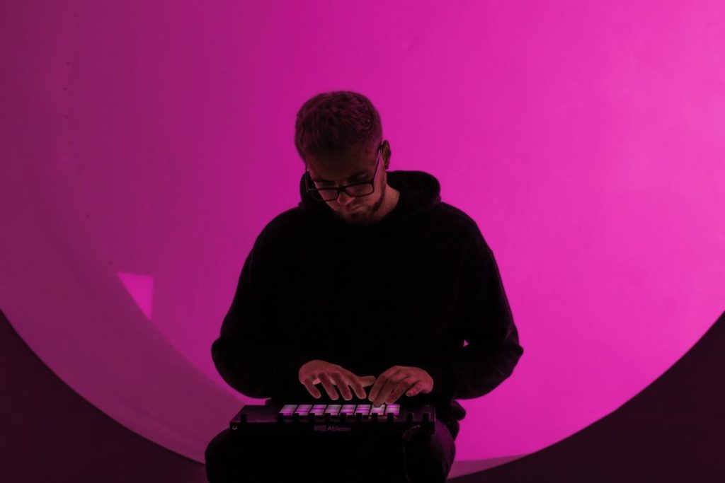 Image if a music producer making beats with a midi controller. Source: unsplash