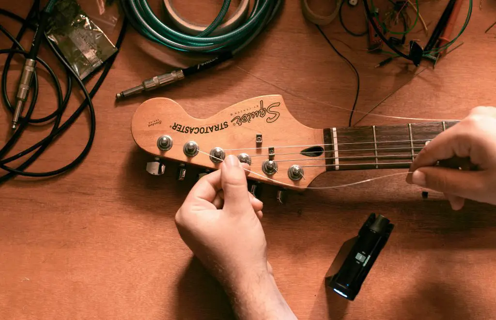 Image of a guitar string being adjusted. Source: unsplash