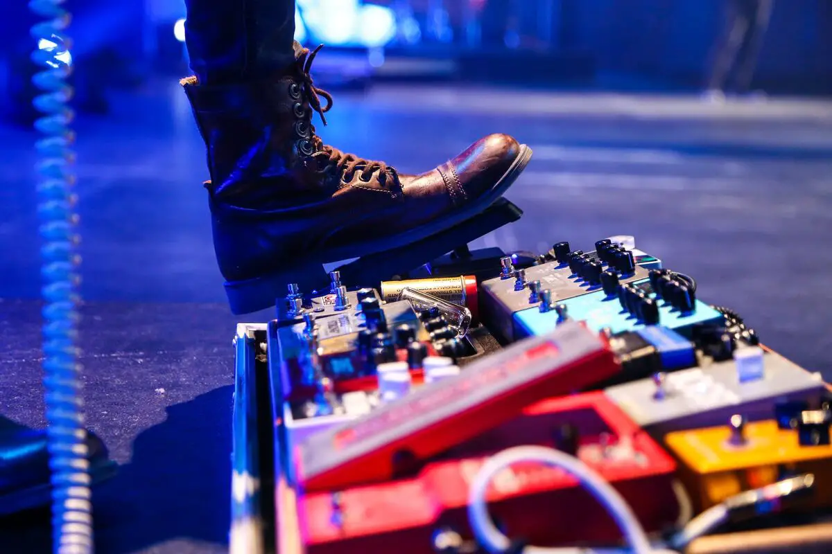 Image of a guitarist stepping on a wah wah pedal. Source: unsplash