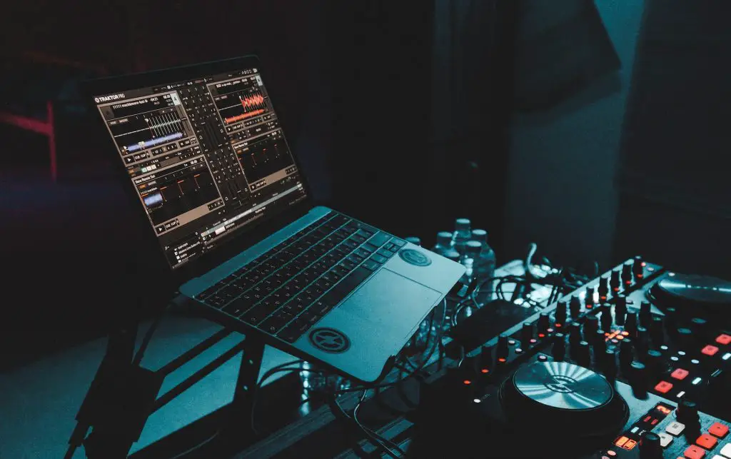 Image of a laptop with an audio software and a dj mixer. Source: unsplash