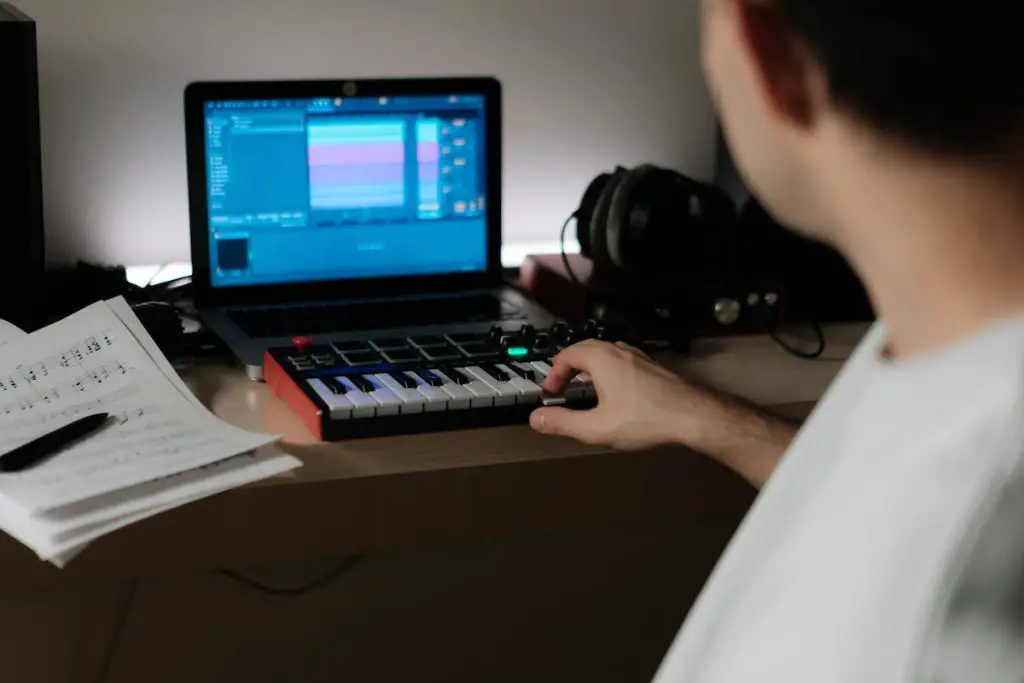 Image of a man playing a keyboard synthesizer. Source: unsplash