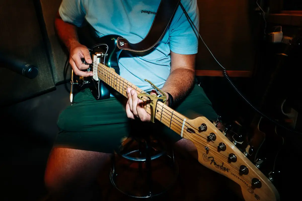 Image of a man playing an electric guitar with a tremolo. Source: unsplash